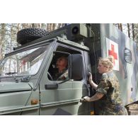 Une infirmière de l'équipe médicale allemande porte secours à un soldat néerlandais blessé à bord d'une ambulance, lors d'un exercice sanitaire au sein du camp de Pabradé en Lituanie.