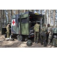Des éléments des équipes médicales françaises, allemandes et néerlandaises portent secours à un soldat blessé à bord d'une ambulance lors d'un exercice sanitaire au sein du camp de Pabradé, en Lituanie.