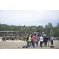 Des journalistes de télévision retransmettent une démonstration des forces en direct du camp de Pabradé, en Lituanie.