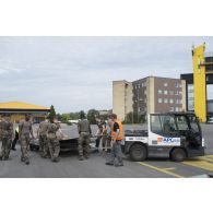 Des soldats mettent en place des palettes pour le chargement de fret au sein de l'aéroport de Kaunas, en Lituanie.