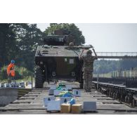 Un élément du peloton de transport et maintenance (PTM) du 511e régiment du train (511e RT) guide le chargement d'un véhicule blindé de combat d'infanterie (VBCI) à bord d'un train en gare de Gaiziunai, en Lituanie.