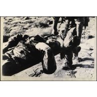 Commando Cobra. Opération du djebel Bou Amoud. Sur le terrain, un soldat blessé est transporté sur un brancard. [légende d'origine]