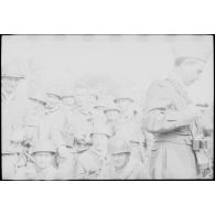 Opération avec le 8e RIM dans le secteur de Wagram. Découverte d'une cache d'armes et de matériels appartenant au FLN/ALN. Portrait de groupe, au centre, avec son appareil photographique, Arthur Smet pose avec ses camarades. [légende d'origine]