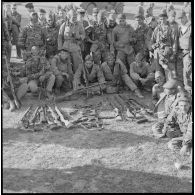 [Opération avec le commando Georges dans le secteur de Fenouane, près de la ferme Garrigues. Soldats posant devant les armes récupérées dont un fusil-mitrailleur.]