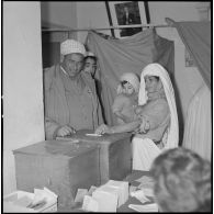 [Algérienne déposant son bulletin de vote dans une urne à Wagram.]