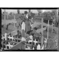La Toussaint à Salonique. Jeune fille fleurissant des tombes de soldats. [légende d'origine]