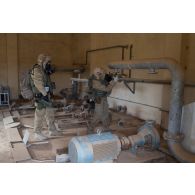 Deux soldats de l'équipe de reconnaissance et d'évaluation NRBC (nucléaire, radiologique, biologique, chimique) attachée au SGTA (sous-groupement tactique d'artillerie) Lion du 3e RAMa intégré à la Task Force Wagram relèvent le niveau de contamination à l'aide d'un compteur lors de la reconnaissance d'un site dans les ruines de la ville irakienne d'Al-Qaïm, située à proximité de la frontière avec la Syrie.