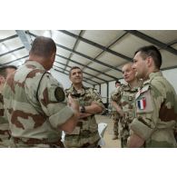 Le  vice-amiral Olivier Coupry, inspecteur général des armées en présence d'officiers français, suite à sa rencontre avec les éléments des forces de la coalition durant sa visite au camp Leclerc de la base aérienne Al-Asad Air Base (AAAB).