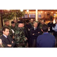 Des militaires et des personnels civils présentent à Alain Richard les locaux du foyer et de la boutique de l'ECOpex à Novo Selo.