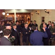 Des militaires et des personnels civils présentent à Alain Richard les locaux du foyer et de la boutique de l'ECOpex à Novo Selo.