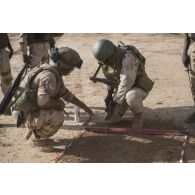 Un instructeur dispense une formation au déminage et à la dépollution à des soldats maliens au moyen d'une sonde lors d'une instruction à Ménaka.