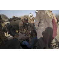 Des soldats français et maliens puisent de l'eau d'un puits avec l'aide d'un civil lors d'une opération dans le Liptako.