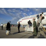 Embarquement de ressortissants évacués par la passerelle de l'Airbus A340 de l'escadron de transport 3/60 Esterel sur l'aéroport de Tripoli (Libye), sous le regard d'un capitaine membre de l'équipage et d'un agent du ministère des Affaires étrangères.