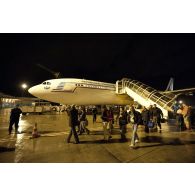 Débarquement de nuit des ressortissants évacués de Tripoli (Libye) en avion Airbus A340 de l'escadron de transport 3/60 Esterel sur l'aéroport de Roissy-en-France, accueillis par des membres de la Croix-Rouge française et des sapeurs-pompiers de la BSPP (Brigade des sapeurs-pompiers de Paris).
