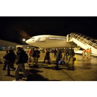 Débarquement de nuit des ressortissants évacués de Tripoli (Libye) en avion Airbus A340 de l'escadron de transport 3/60 Esterel sur l'aéroport de Roissy-en-France, accueillis par des membres de la Croix-Rouge française et des sapeurs-pompiers de la BSPP (Brigade des sapeurs-pompiers de Paris).