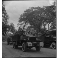 Des GMC blindés transportant des canons antiaériens passent devant la tribune officielle lors du 14 juillet 1951 à Hanoï.