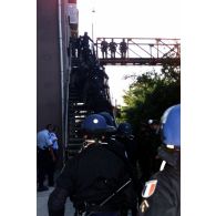 Intervention des gendarmes de la KFOR montant sur la passerelle conduisant au groupe des ouvriers.