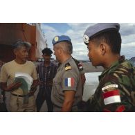 Un capitaine écoute un Cambodgien qui réclame une facture.