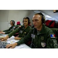 Portrait du lieutenant-colonel Arnaud Bourguignon, chef de mission E3F (tactical director), à son poste aux côtés d'un capitaine et d'un adjudant, lors d'une mission de contrôle aérien sur la Libye à bord d'un avion de détection Awacs.