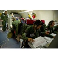 Groupe d'adjudants contrôleurs défense et armes à leurs postes devant les écrans radar, lors d'une mission de contrôle aérien sur la Libye à bord d'un avion de détection Awacs.