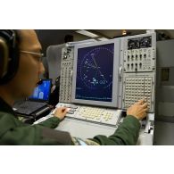 Portrait d'un sergent opérateur d'ESM (electronic support measure ou système d'écoute d'émissions) devant son écran radar, lors d'une mission de contrôle aérien sur la Libye à bord d'un avion de détection Awacs.
