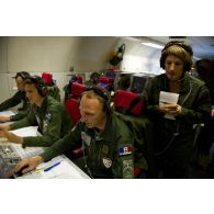 Portrait du lieutenant-colonel Arnaud Bourguignon, chef de mission E3F (tactical director), à son poste aux côtés d'un capitaine et d'un adjudant, en présence d'une journaliste, lors d'une mission de contrôle aérien sur la Libye à bord d'un avion de détection Awacs.