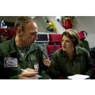 Interview du lieutenant-colonel Arnaud Bourguignon, chef de mission E3F (tactical director), par une journaliste, lors d'une mission de contrôle aérien sur la Libye à bord d'un avion de détection Awacs.