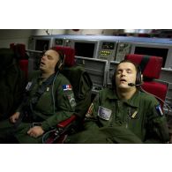 Lors du vol de retour de mission de contrôle aérien sur la Libye à bord d'un avion de détection Awacs, sieste de deux opérateurs de surveillance.