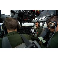 Groupe des pilotes et du navigateur du 36e EDCA (escadron de détection et de contrôle aéroporté), dont un lieutenant-colonel, aux commandes en cabine de pilotage, lors d'une mission de contrôle aérien sur la Libye à bord d'un avion de détection Awacs.