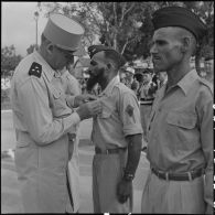 Le général Cogny, commandant en chef des FTNV (forces terrestres du Nord-Vietnam), remet une décoration à un soldat.