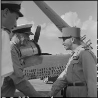 Le général Lambe (à gauche), commandant en chef des forces navales britanniques dans le sud-est asiatique, et le général Masson (à droite), adjoint au commandant en chef des FTNV (forces terrestres du Nord-Vietnam), se serrent la main sur un des aérodromes d'Hanoï.