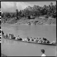 En compagnie d'autorités civiles et militaires, les généraux Ely et Salan traversent le Mékong sur une pirogue à moteur.