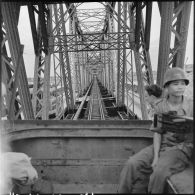 Soldat armé d'une mitrailleuse Browning dans un train passant sur le pont Paul-Doumer (aujourd'hui Long Biên).