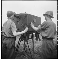 Lors d'une école à feu du 411e RAAA  (régiment d'artillerie antiaérienne) de la DMC (division de marche de Constantine), deux artilleurs utilisent un système de visée et de mesure d'un canon de 40 mm Bofors.