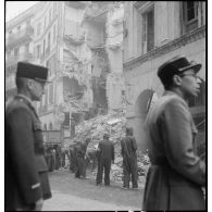 Suite au bombardement allemand de la nuit du 18 au 19 avril 1943, des volontaires de la défense passive déblaient des gravats dans une rue donnant sur la place du Gouvernement à Alger.