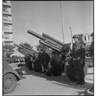 Sur le champ de manoeuvres d'Alger, lors d'une cérémonie franco-américaine de remise de matériels américains aux troupes françaises, des artilleurs des 1er et 2e groupes du 63e RAA (régiment d'artillerie d'Afrique) de la 2e DIM (division d'infanterie marocaine) sont sur les rangs avec leurs nouvelles dotations d'obusiers de 105 mm Howitzer M2.