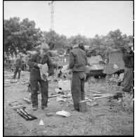 Des chasseurs du 5e RCA (régiment de chasseurs d'Afrique) de la 1re DB (division blindée) inventorient les matériels et lots de bord équipant leurs chars légers Stuart M5 A1 dans un champ en bordure d'une route menant à Blida.
