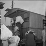 Des réfugiés montent dans un wagon à quai en gare d'Hanoï.