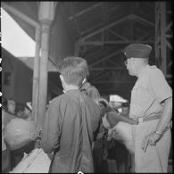 Un officier du CEFEO (Corps expéditionnaire français en Extrême-Orient ) et des réfugiés sur un quai de la gare ferroviaire d'Hanoï.