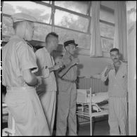 Le colonel Lalande en visite à l'hôpital militaire Lanessan, partage un verre avec trois hommes.