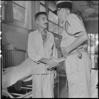 Le colonel Lalande (à droite) serre la main d'un homme hospitalisé à l'hôpital militaire Lanessan.