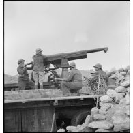 Chargement et mise en batterie par des artilleurs du 62e RAA (régiment d'artillerie d'Afrique) d'un canon de 75 mm, modèle 1915, monté sur un affût marine et une remorque dans le secteur de Bou Arada.