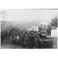Des soldats italiens se trouvent près de l'épave d'un canon automoteur allemand type 40 (Sturmgeschütz 40) détruit dans le village de Patrimonio.
