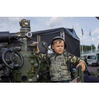 Portrait d'un enfant aux commandes d'un obusier FH70 estonien à Tallinn, en Estonie.