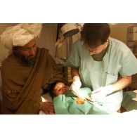 Nettoyage du pansement d'un enfant afghan par le médecin colonel Potier à l'hôpital militaire allemand.