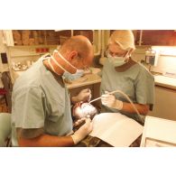 Dentiste allemand avec son assistante intervenant sur un patient, Kaboul.