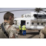 Des éléments du GTD Bercheny sont en transit aux côtés d'un hélicoptère Mil Mi-8 HIP des Nations Unies sur la piste de Gao.