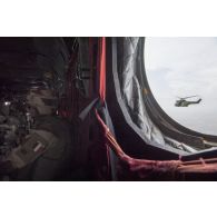 Un hélicoptère de transport Puma SA-330 escorte le convoyage aérien de soldats embarqués à bord d'un hélicoptère Chinook CH-47.