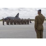 Le général de brigade aérienne Philippe Adam salue pendant l'hymne national entonné lors d'une cérémonie sur la base de Niamey.