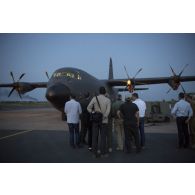 Des membres de la commission de la Défense nationale et des forces armées de l'Assemblée nationale assistent à la présentation d'un avion de transport Super Hercules C-130J sur la base de Niamey.